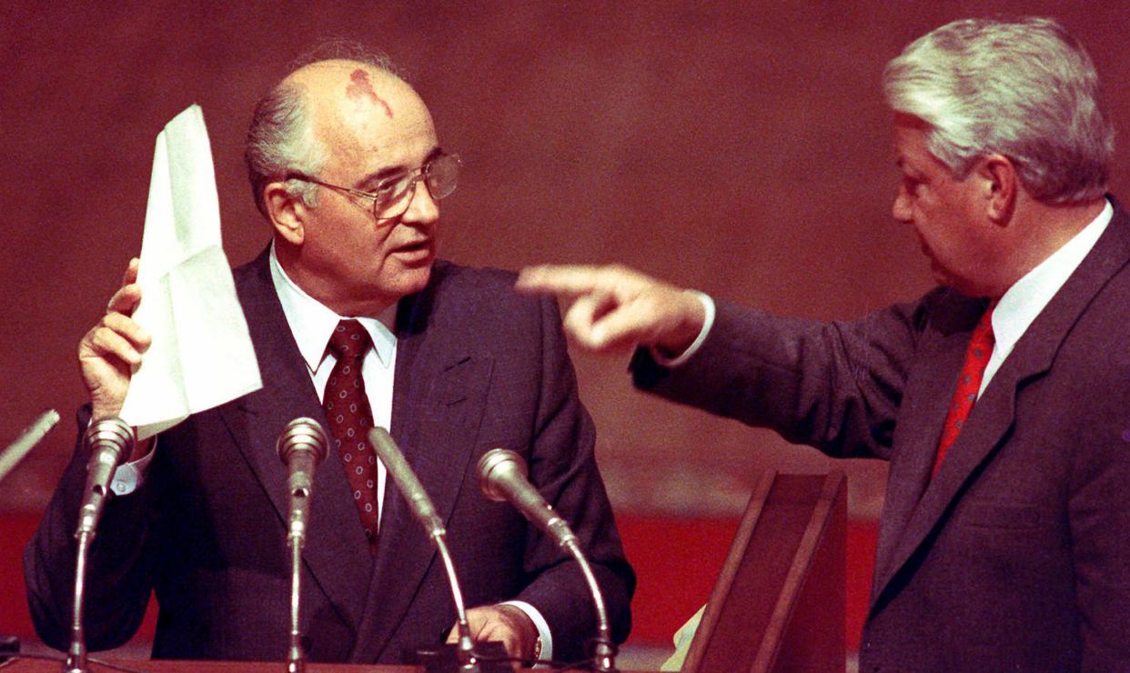 In this Friday, Aug. 23, 1991 file photo, Soviet President Mikhail Gorbachev, left, holds stenographic notes given to him by Russian Federation President Boris Yeltsin, right, at a special session of the Russian Federation Parliament. 