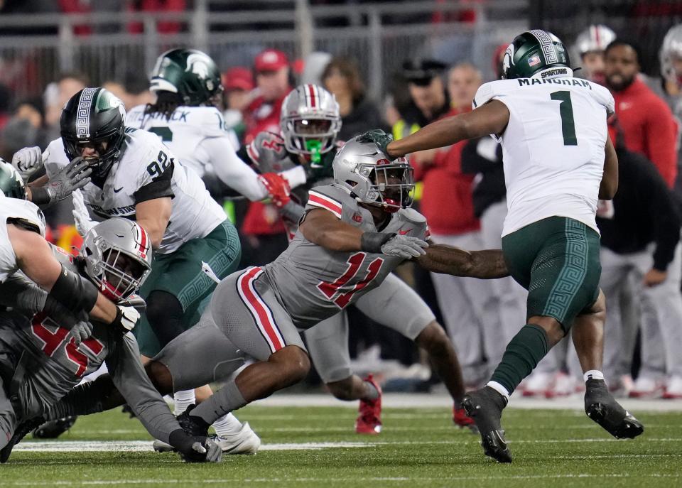 Nov 11, 2023; Columbus, Ohio, USA; Michigan State Spartans defensive back Jaden Mangham (1) avoids a tackle by Ohio State Buckeyes linebacker C.J. Hicks (11) in the second half of the NCAA football game against Michigan State University at Ohio Stadium. The Buckeyes defeated the Spartans 38 to 3.