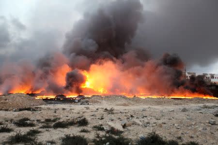 Fire rises from oil wells, set ablaze by Islamic State militants before fleeing the oil-producing region of Qayyara, Iraq, which has been recaptured by Iraqi forces, August 29, 2016. REUTERS/Azad Lashkari