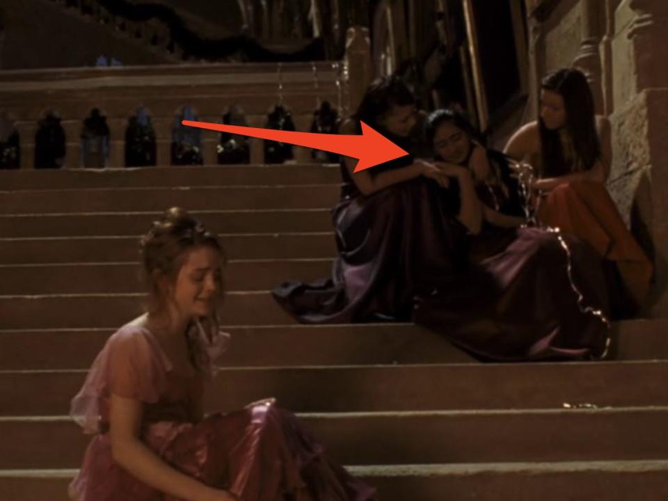 arrow pointing at three girls crying on the steps of hogwarts behind hermione crying on the step in goblet of fire