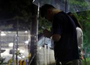 A Chinese animation fan who lives in Osaka mourns for the victims in front of Kyoto Animation's studio building which was burnt out by arson attack in Kyoto