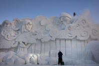 Two workers remove fresh snow piled on a large snow sculpture at the annual Sapporo Snow Festival, Feb. 4, 2020, in Sapporo, Hokkaido, Japan. After two months of almost no snow, Japan's northern city of Sapporo was overwhelmed with the white stuff. The snowfall was good news for tourism, for the “look”of the annual Sapporo Snow Festival, and for organizers who hope to bring the 2030 Winter Olympics to the city. Sapporo hosted the Winter Olympics back in 1972. (AP Photo/Jae C. Hong)