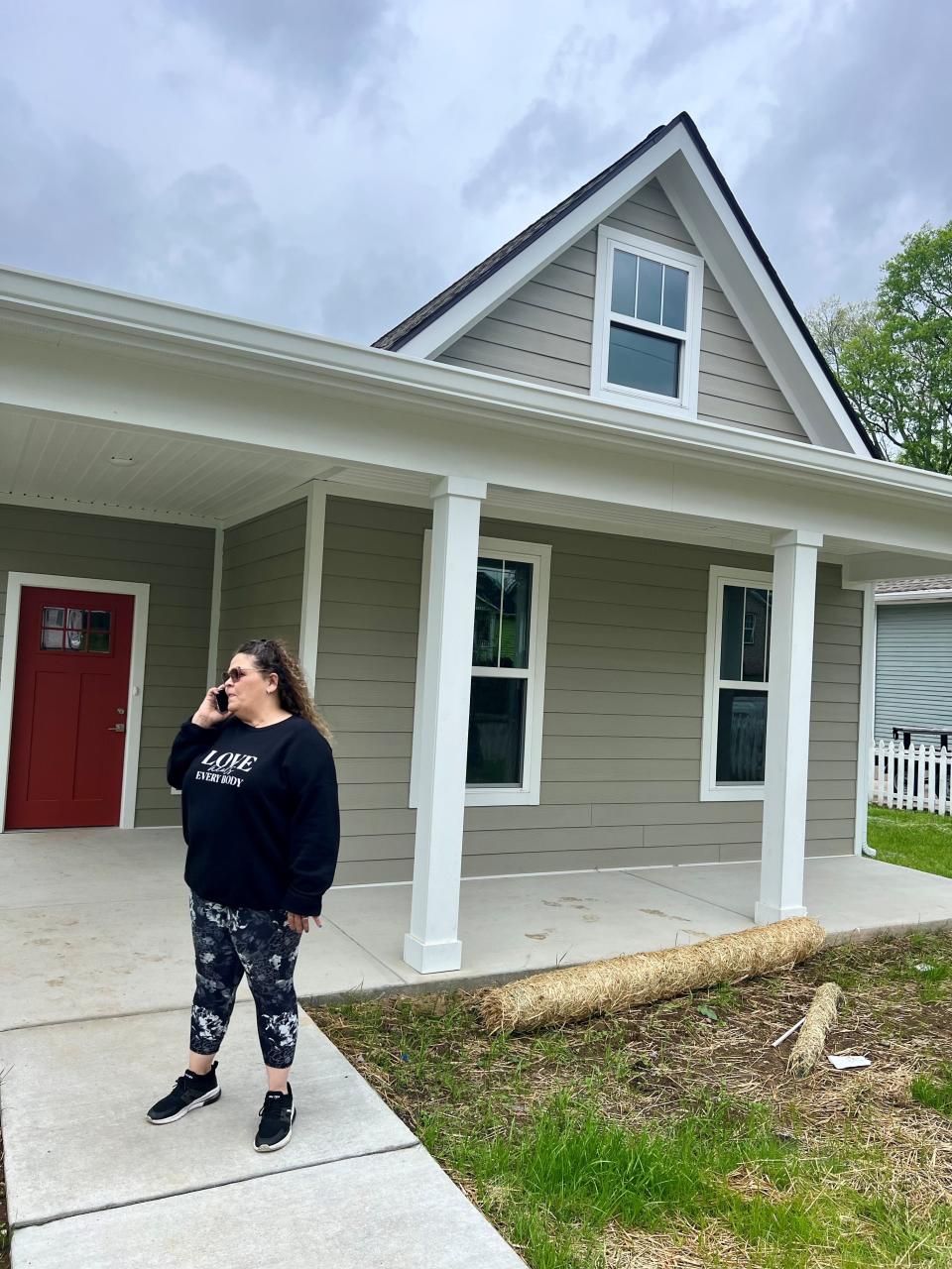 Diana Burke, 57, on the phone April 10, 2024, in North Nashville in front of the first home she has ever purchased. Burke, a sex trafficking and addiction survivor, did so with help from three nonprofits, including Thistle Farms, a women's recovery program and social justice business enterprise where she works