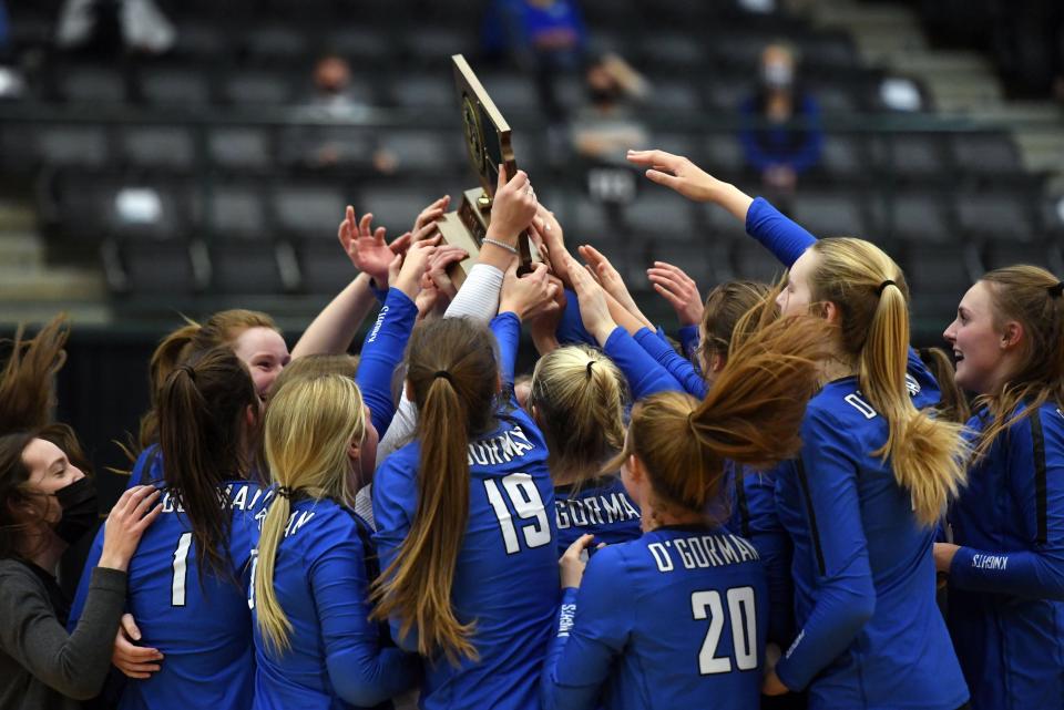 The O'Gorman volleyball team holds their trophy aloft after winning the class AA state volleyball championship on Saturday, November 21, at Swiftel Center in Brookings.