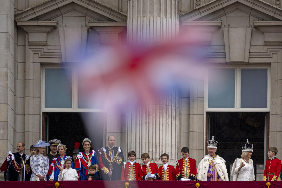 FILE - Britain's King Charles III and Queen Camilla and family look at the crowd from the balcony of Buckingham Palace after the coronation ceremony in London, Saturday, May 6, 2023. A year after the death of Queen Elizabeth II triggered questions about the future of the British monarchy, King Charles III’s reign has been marked more by continuity than transformation, by changes in style rather than substance. (AP Photo/Andreea Alexandru, File)