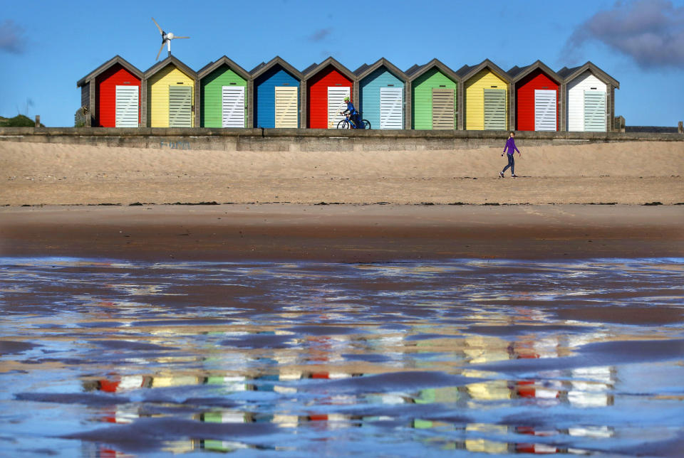 People take their daily exercise this morning at the colourful Blyth Beach huts in Northumberland, as the UK continues in lockdown.