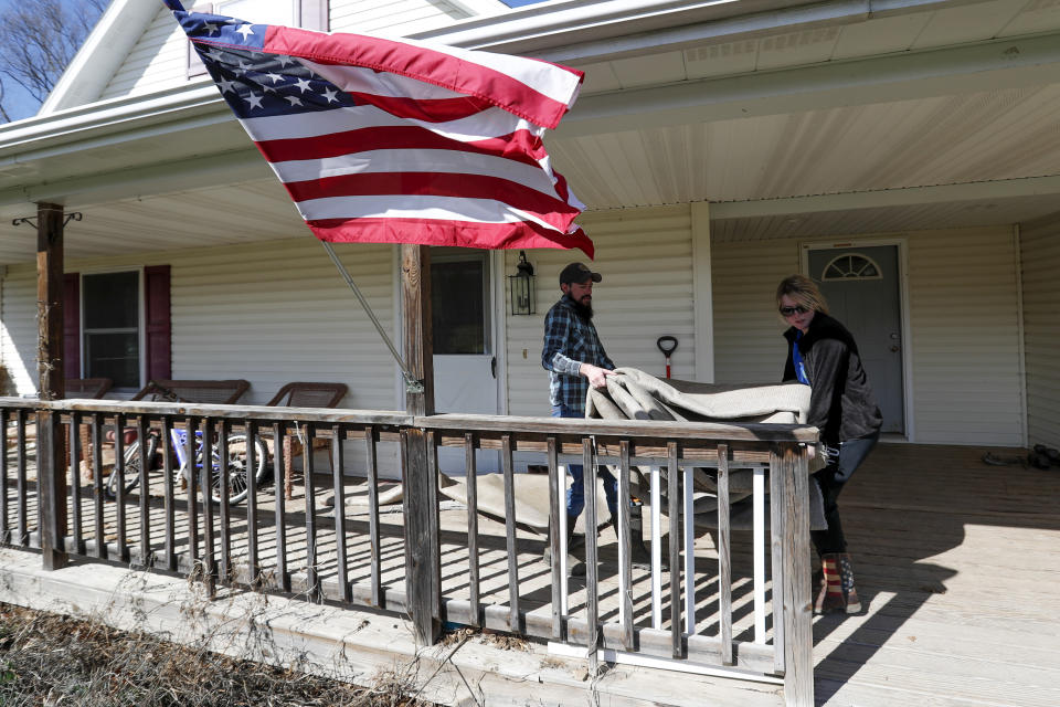 In this Friday, March 13, 2020 photo, Nic Talbott, left, gets help from his sister Paige Talbott carrying carpeting he removed from his home in Lisbon, Ohio. Nic Talbott is a plaintiff in one of four lawsuits filed in federal courts challenging a Trump administration policy barring transgender Americans from enlisting in the military. (AP Photo/Keith Srakocic)