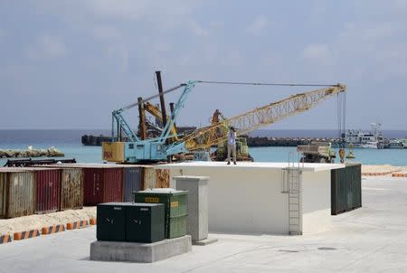 A journalist takes photos next to a construction site of a pier, in Itu Aba, which the Taiwanese call Taiping, at the South China Sea, March 23, 2016. REUTERS/Fabian Hamacher