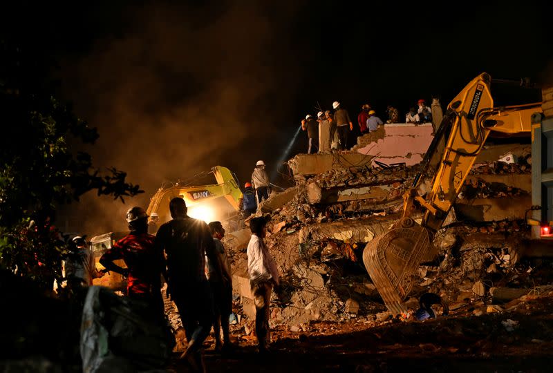 Rescue workers remove the debris as they search for survivors after a five-storey building collapsed in Mahad