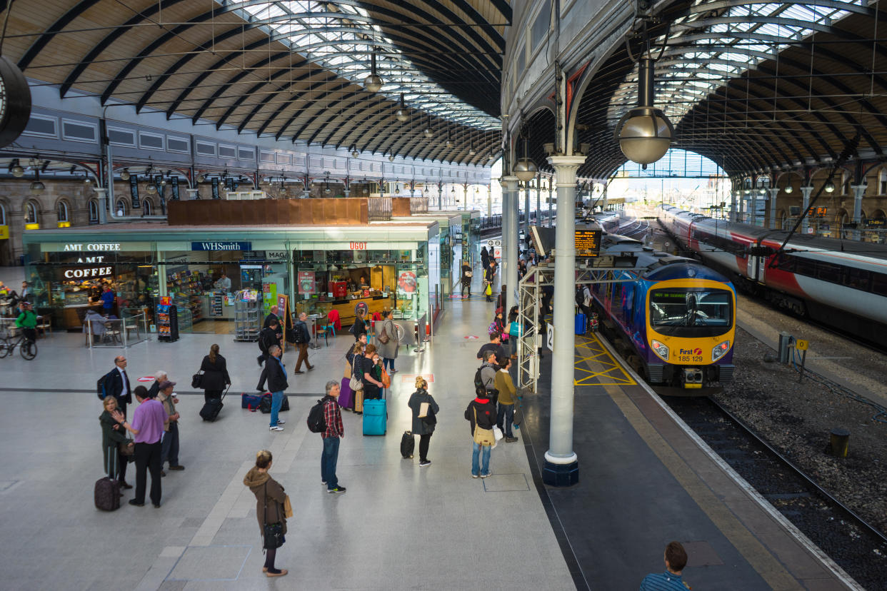 Newcastle Upon Tyne, UK, England - September 15, 2015:  People commuting over the main platform of Newcastle Central station, where a train awaits.