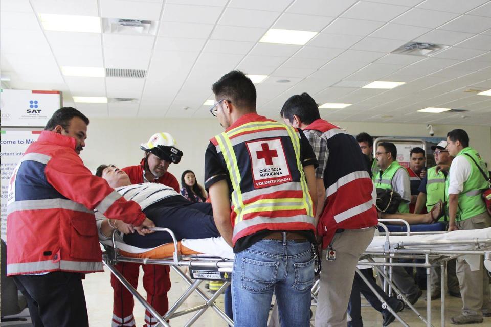 In this photo released by Red Cross Durango communications office, Red Cross workers attend airline passengers who survived a plane crash, at a medical center in Durango, Mexico, Tuesday, July 31, 2018. An Aeromexico jetliner crashed while taking off during a severe storm, smacking down in a field nearly intact then catching fire, and officials said it appeared everyone on board escaped the flames. (Red Cross Durango via AP)