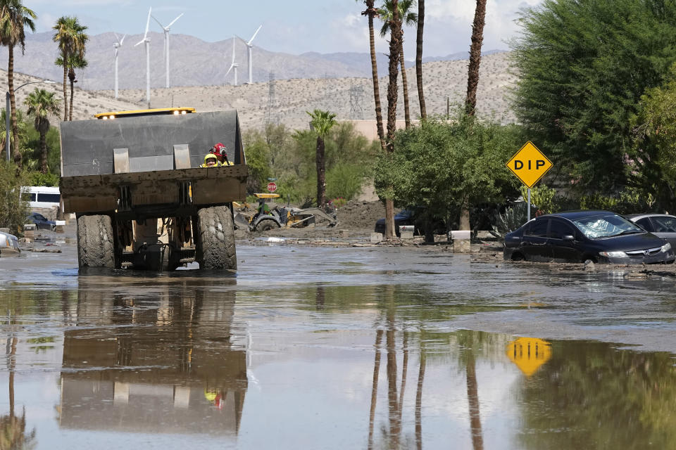 Los bomberos utilizan un camión para rescatar a una persona de un centro tras la inundación de un calle por las lluvias de la tormenta tropical Hilary, el 21 de agosto de 2023, en Cathedral City, California. (AP Foto/Mark J. Terrill)