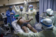 Nurses and doctors clear themselves before defibrillating a patient who tested positive for COVID-19 and suddenly went "Code 99," or into cardiac arrest, in Yonkers, N.Y., April 20, 2020. The emergency room team successfully revived the patient. Associated Press photographer John Minchillo says of witnessing their heroic efforts: “Seeing the medical team risk death to save the life of a stranger, knowing the air surrounding us was teeming with particles from intubated patients' lungs, left me grateful for good people in this world. My respect for these New Yorkers is boundless.” (AP Photo/John Minchillo)