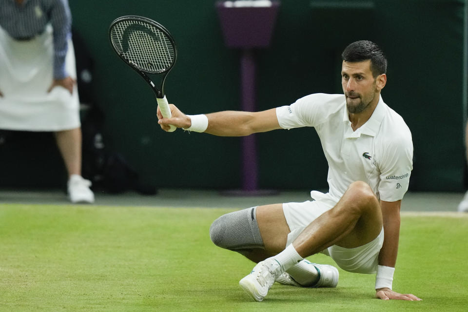 Novak Djokovic of Serbia falls during his fourth round match against Holger Rune of Denmark at the Wimbledon tennis championships in London, Monday, July 8, 2024. (AP Photo/Mosa'ab Elshamy)