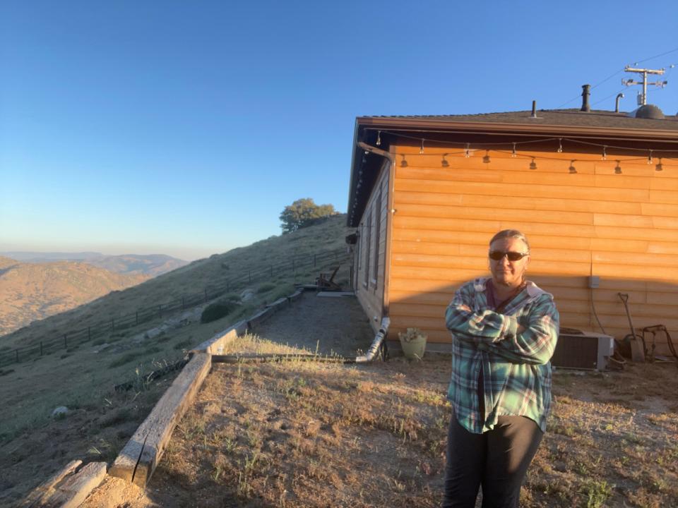 Anjali Tierra, pictured with her home in Tehachapi, California, has been living without homeowners insurance since 2019.