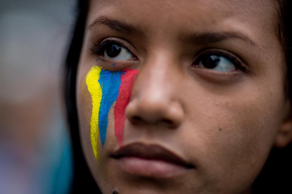 A demonstrator wearing painted stripes that represent Venezuela's national flag attends a rally with humans rights activist in Caracas, Venezuela, Friday, Feb. 28, 2014. The start of a weeklong string of holidays leading up to the March 5 anniversary of former President Hugo Chavez's death has not completely pulled demonstrators from the streets as the government apparently hoped. President Nicolas Maduro announced this week that he was adding Thursday and Friday to the already scheduled long Carnival weekend that includes Monday and Tuesday off, and many people interpreted it as an attempt to calm tensions. (AP Photo/Rodrigo Abd)