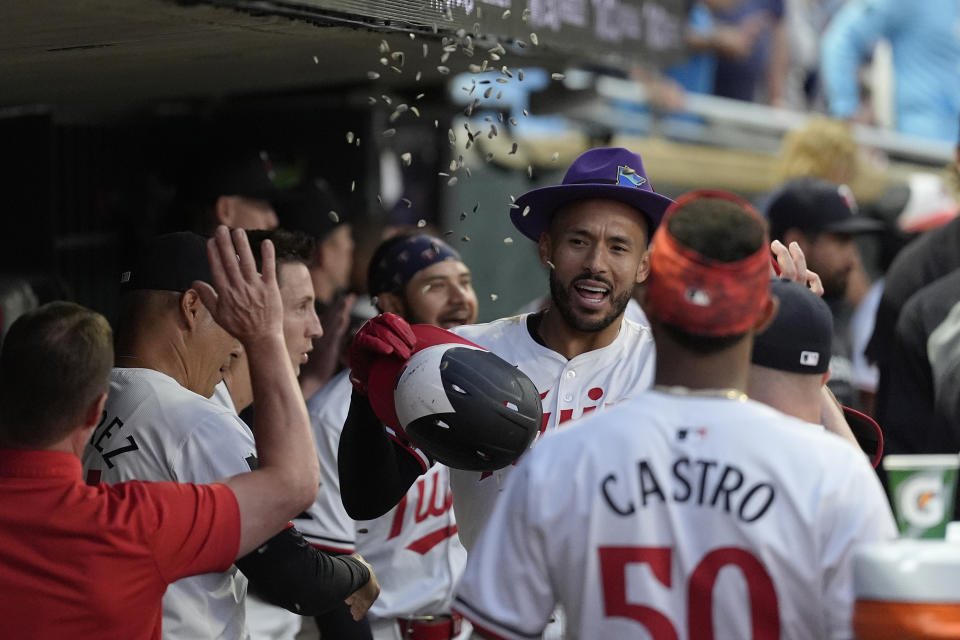 Minnesota Twins' Carlos Correa, center, celebrates in the dugout after hitting a solo home run during the eighth inning of a baseball game against the Detroit Tigers, Tuesday, July 2, 2024, in Minneapolis. (AP Photo/Abbie Parr)