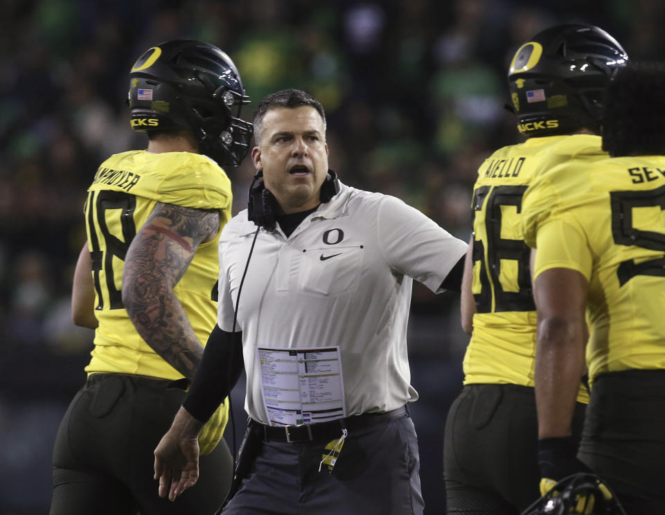 FILE - In this Saturday, Nov. 16, 2019 file photo, Oregon coach Mario Cristobal welcomes his team back to the sideline after a first-quarter score against Arizona in an NCAA college football game in Eugene, Ore. Oregon has won the past two Pac-12 championships and is poised to be in contention to win another. Coach Mario Cristobal has pulled in the conference's top recruiting class the past two seasons and the 2021 class was sixth nationally, including pro-style quarterback Ty Thompson, who will likely battle Anthony Brown for the starting spot. (AP Photo/Chris Pietsch, File)