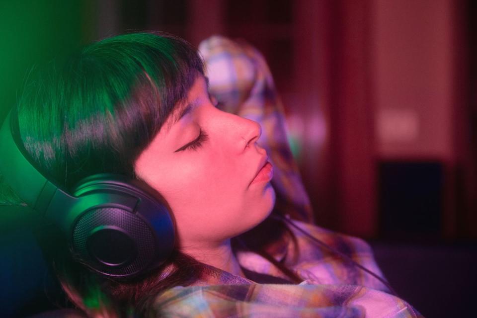 young woman listening music at home on sofa