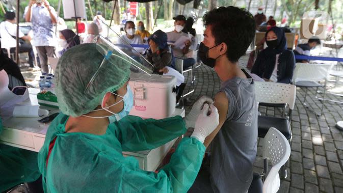 Vaksinator menyuntikkan vaksin COVID-19 untuk warga di Taman Dadap Merah, Kebagusan, Jakarta, Sabtu (10/7/2021).  Pelaksanaan vaksinasi melalui mobil vaksin keliling juga diperuntukkan untuk anak usia 12 tahun ke atas. (Liputan6.com/Helmi Fithriansyah)
