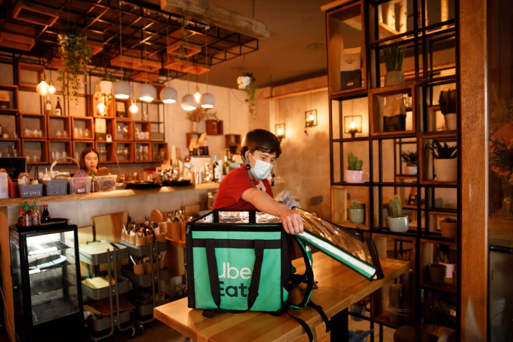 PRODUCTION - 02 September 2021, Berlin: Silvan, a driver for food delivery service Uber Eats, picks up food with a transport box at restaurant ETE in the Friedrichshain district. Photo: Carsten Koall/dpa (Photo by Carsten Koall/picture alliance via Getty Images)