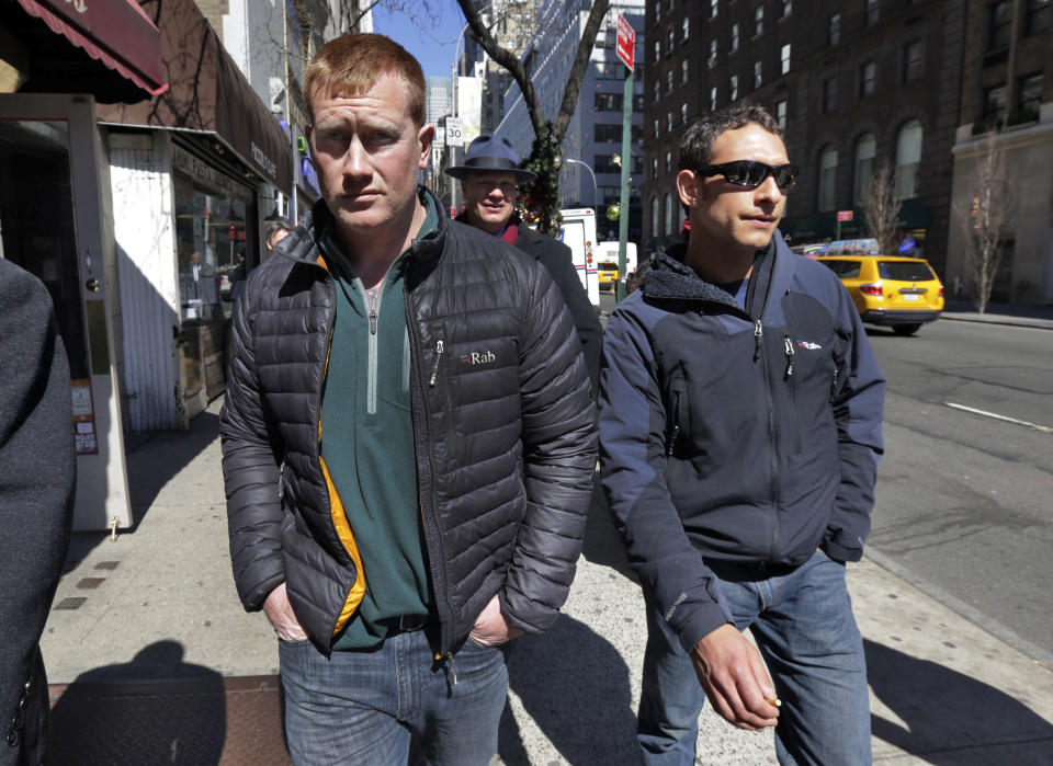 James Brady, left, and Andrew Rossig, right, two parachutists who jumped from One World Trader Center in September 2013, are accompanied by attorney Timothy Parlatore to surrender to police, in New York, Monday, March 24, 2014. Monday's arrests come eight days after a 16-year-old was arrested on charges of climbing up to the top of the nation's biggest skyscraper. Police had no immediate information on Monday's arrests. They had said they were looking for two parachutists seen floating near the building Sept. 30. The defense attorneys say three accused jumpers and an alleged accomplice on the ground are expecting to face felony burglary charges. The attorneys say the defendants are experienced BASE jumpers, the acronym stands for "building, span, antenna, earth." The lawyers say the men took care to keep from endangering anyone. (AP Photo/Richard Drew)