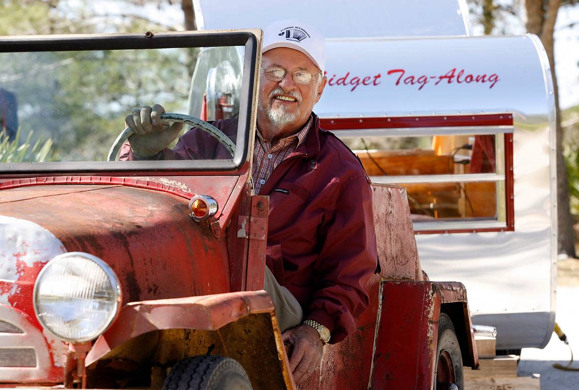 Lawrence Perry sits in his American-manufactured 1956 King Midget which can pull the 200 pound trailer he made which has a small bed and slide-out kitchen at Lake Manatee where the Tin Can Tourists gathered.