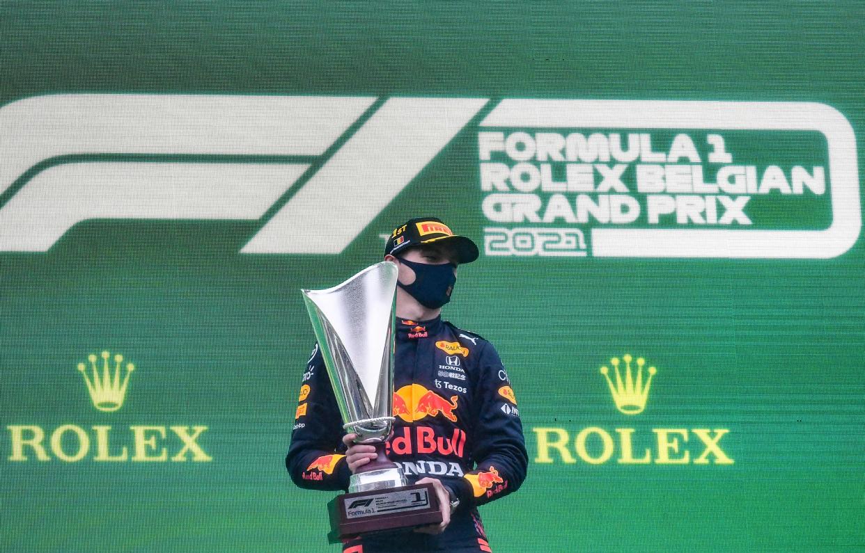 Max Verstappen poses with the trophy as he celebrates his first place on the podium at the Spa-Francorchamps circuit.