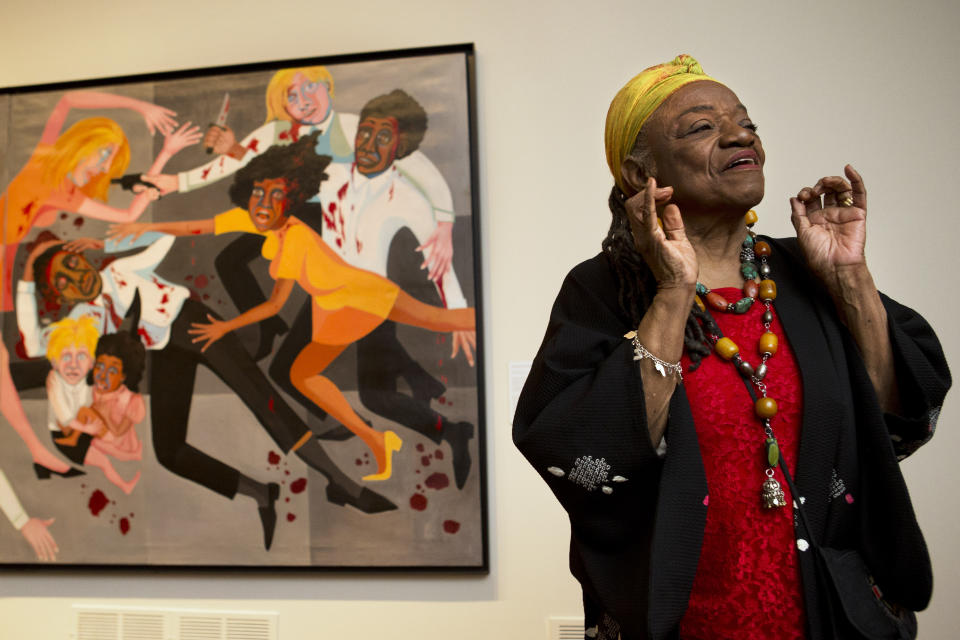 FILE - Artist Faith Ringgold talks about her artwork in front of her painting, "Die (1967)" during a press preview of her exhibition, "American People, Black Light: Faith Ringgold's Paintings of the 1960s" at the National Museum of Women in the Arts in Washington, June 19, 2013. Ringgold, an award-winning author and artist who broke down barriers for Black female artists and became famous for her richly colored and detailed quilts combining painting, textiles and storytelling, died Friday, April 12, 2024, at her home in Englewood, N.J. She was 93. (AP Photo/Jacquelyn Martin, File)