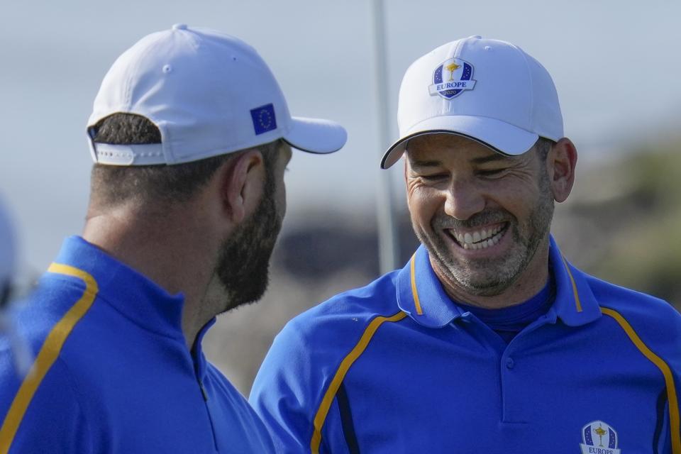 Team Europe's Sergio Garcia smiles with teammate Team Europe's Jon Rahm during a foursome match the Ryder Cup at the Whistling Straits Golf Course Friday, Sept. 24, 2021, in Sheboygan, Wis. (AP Photo/Ashley Landis)