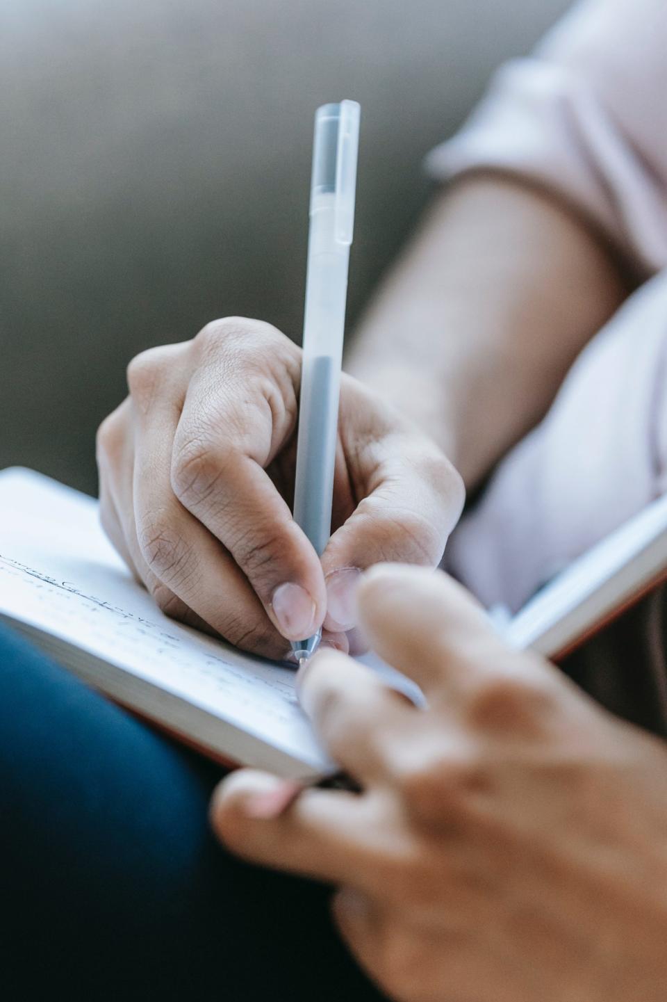 A hand writing in a notebook