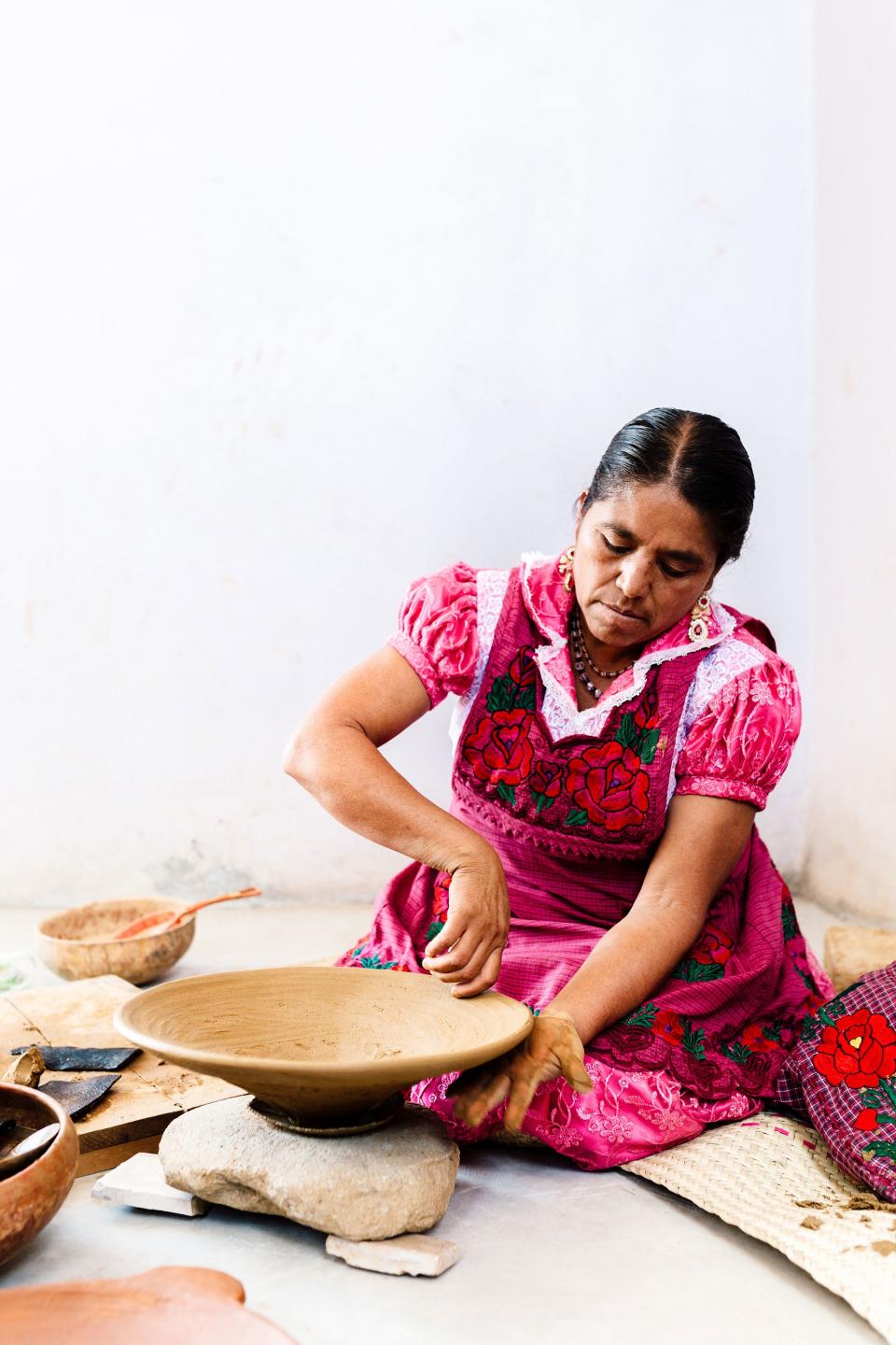 Macrina shapes a serving platter by hand, using techniques and methods passed on from her mother, who learned from her grandmother and her great-grandmother before her. No potter’s wheel was used to shape these beautiful objects; they are instead made entirely by hand. That dense red clay had been dug up from the surrounding mountains days earlier. The women travel there, often in the intense desert heat, and use simple tools to unearth it.