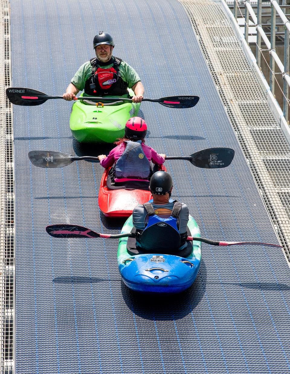 Kayakers ride the conveyor up to the upper pond as training continues, on Saturday June 10, 2023, while Montgomery Whitewater prepares for its July opening in Montgomery, Ala. 