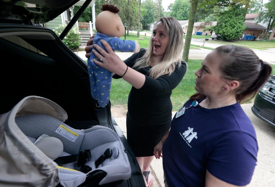 After successfully learning how to buckle a doll into an infant car seat, Jessica Henson, 33, of Warren, has fun with the doll before she and Renee Zarr, a child passenger safety technician and instructor at the Children's Hospital of Michigan, moved to the back seat of Henson's SUV to learn how to install the base and car seat at her home on July 27, 2023. Henson, who is 32 weeks pregnant, had Zarr come to her home to learn how it all works.