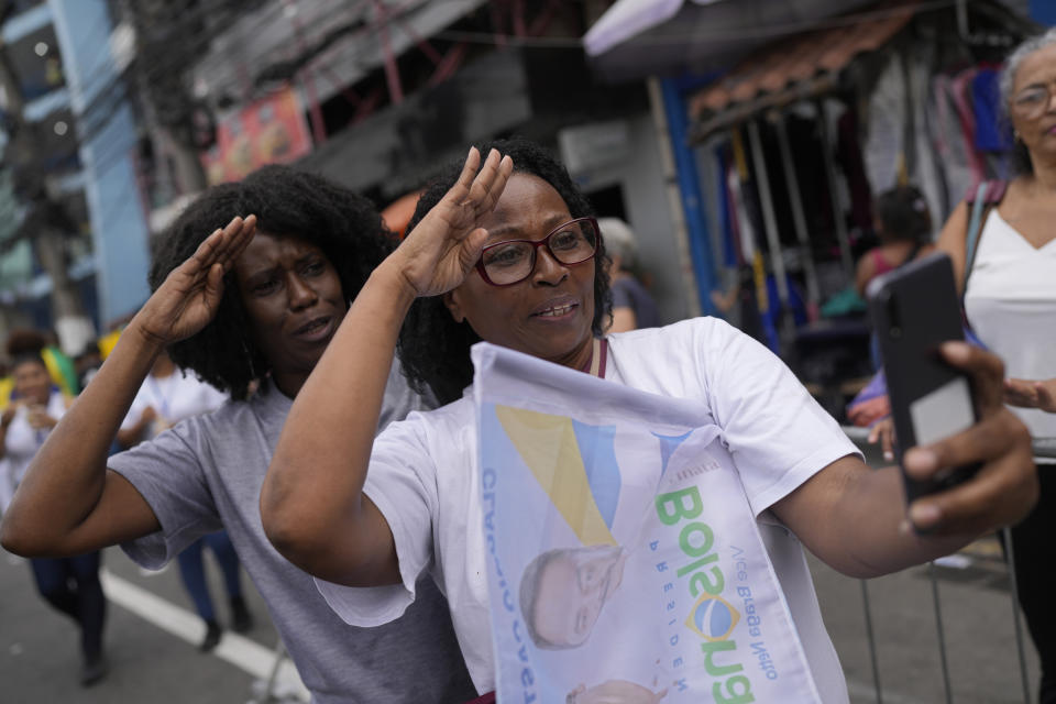 Supporters of Brazilian President Jair Bolsonaro dance as they take a selfie at the end of his campaign rally for reelection in Duque de Caxias, Rio de Janeiro state, Brazil, Friday, Oct. 14, 2022. The presidential run-off election is set for Oct. 30. (AP Photo/Silvia Izquierdo)