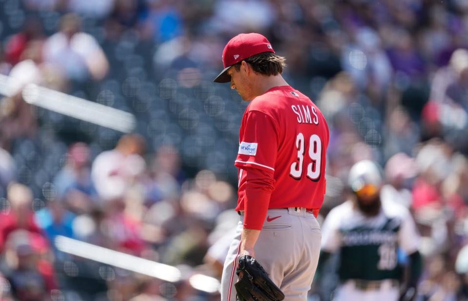 Cincinnati Reds relief pitcher Lucas Sims headed to the dugout after giving up a single, which drove in two runs for the Colorado Rockies.