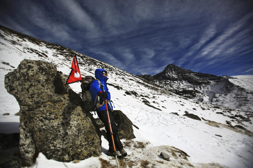 In this photo taken on Feb. 13, 2012 and released by The Great Himalayan Trail, veteran climber Apa Sherpa takes rest as he climbs the Himalayan mountains on the way to the Tshorolpa Glacier Lake, Nepal. The 51-year-old Apa is on a 120-day trek across Nepal to tell villagers about the danger of more devastating flash floods as glacial melt caused by climate change fills high-altitude lakes to the bursting point. (AP Photo/The Great Himalayan Trail) EDITORIAL USE ONLY