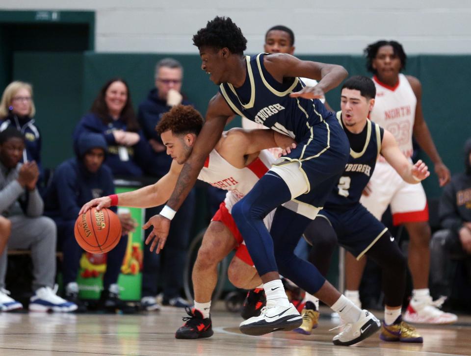 North Rockland's Aidan Brown (11) tries to break away from Newburgh's Deondre Johnson (11) during the boys Class AA regional final  playoff game at Yorktown High School March 11, 2023. North Rockland won the game 53-46.
