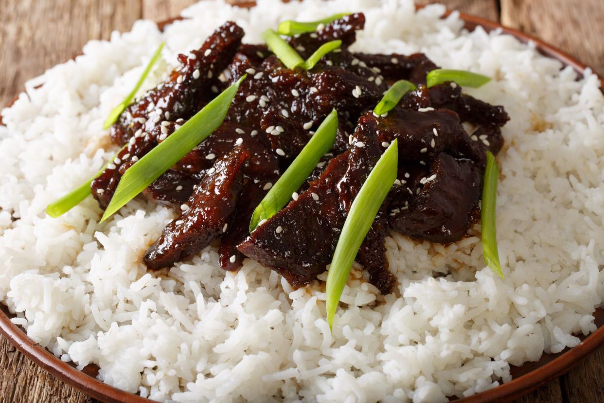 Mongolian beef with sauce and garnish of rice macro on a plate. horizontal