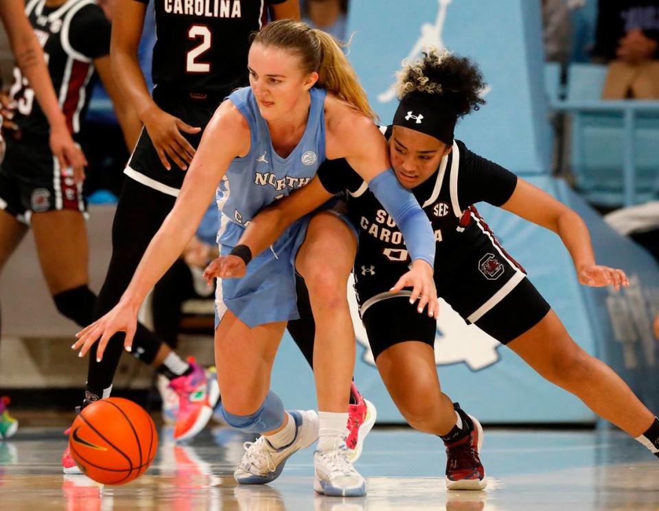 North Carolina’s Alyssa Ustby and South Carolina’s Te-Hina Paopao lunge for a loose ball during the second half of the Tar Heels’ 65-58 loss on Thursday, Nov. 30, 2023, at Carmichael Arena in Chapel Hill, N.C.