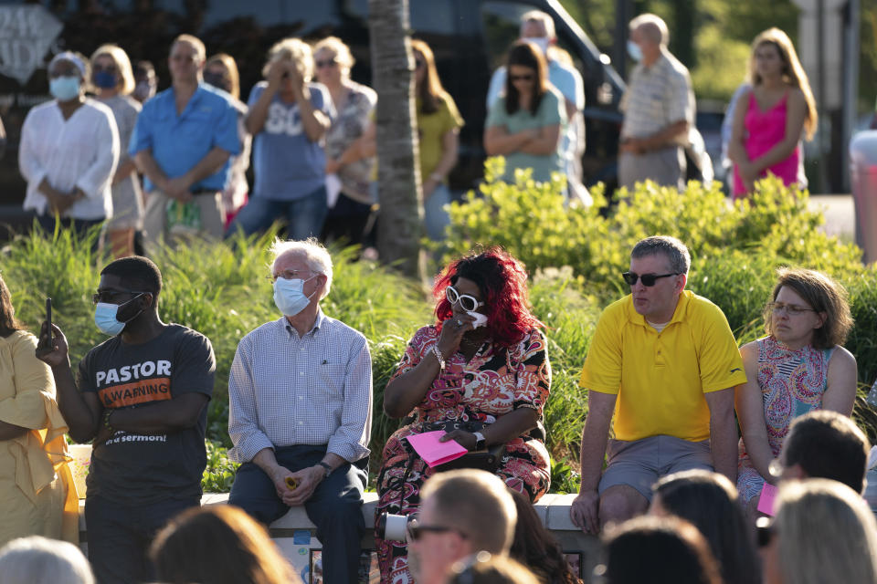 People listen during a memorial service and prayer vigil for the Lesslie family at Fountain Park, Sunday, April 11, 2021, in Rock Hill, S.C. Dr. Robert Lesslie and his wife, Barbara Lesslie, their grandchildren Adah Lesslie and Noah Lesslie, and two men working at the Lesslie home, Robert Shook and James Lewis, were fatally shot last week by former NFL player Phillip Adams. (AP Photo/Sean Rayford)