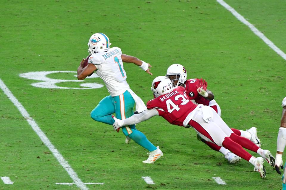 Nov 8, 2020; Glendale, Arizona, USA; Miami Dolphins quarterback Tua Tagovailoa (1) slips a tackle by Arizona Cardinals outside linebacker Haason Reddick (43) and linebacker Isaiah Simmons (48) during the second half  at State Farm Stadium. Mandatory Credit: Matt Kartozian-USA TODAY Sports