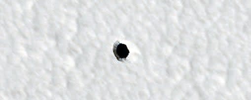 Dieses Bild aus dem Jahr 2022, aufgenommen von der HiRISE-Kamera an Bord des Mars Reconnaissance Orbiters der Nasa, hat die Diskussion um die mysteriösen Löcher auf dem Mars neu entfacht. - Copyright: NASA/JPL-Caltech/UArizona