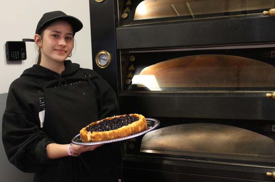 Royal's Mollete Barcelona Bakery employee Mallory Standifer of Monroe prepares to serve blueberry cheesecake.