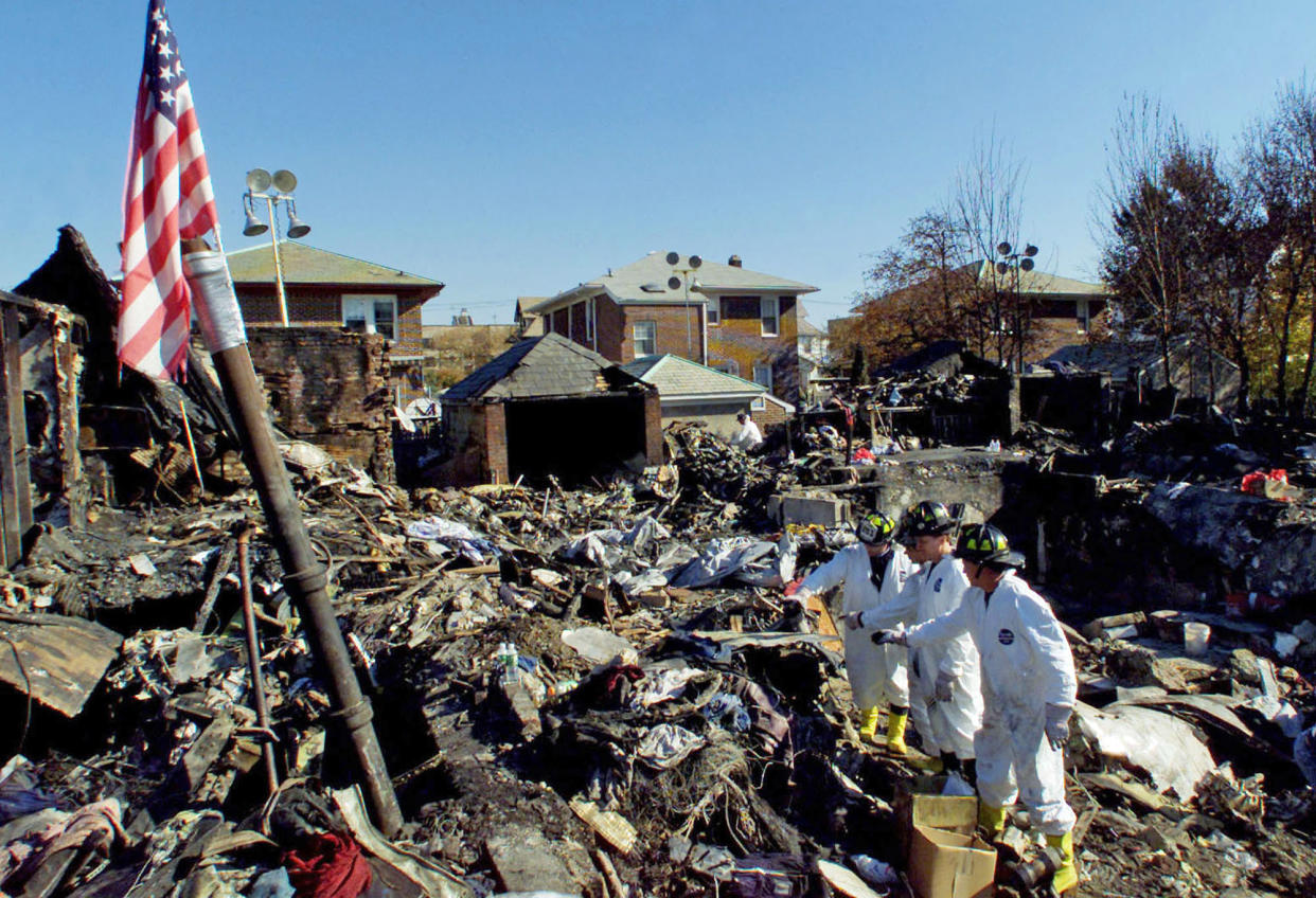 Firefighters recover evidence and human remains from the crash of American Airlines Flight 587 in the Rockaway Beach section of Queens, N.Y., on Nov. 14, 2001. (Jim Bourg / Pool via AP)