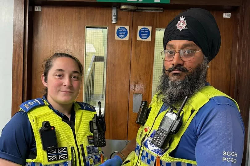 South Wales Police officers (pictured) holding the block of cannabis