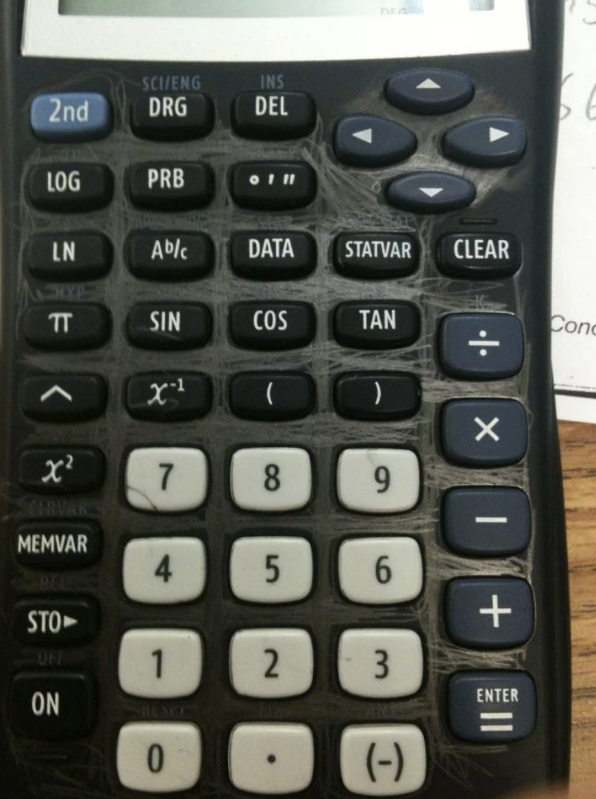 A calculator with scribbled writing on it