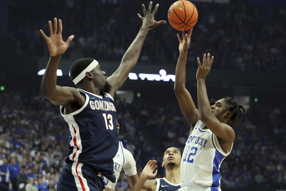 Kentucky's Antonio Reeves (12) has his shot pressured by Gonzaga's Graham Ike (13) during the first half of an NCAA college basketball game, Saturday, Feb. 10, 2024, in Lexington, Ky. (AP Photo/James Crisp)