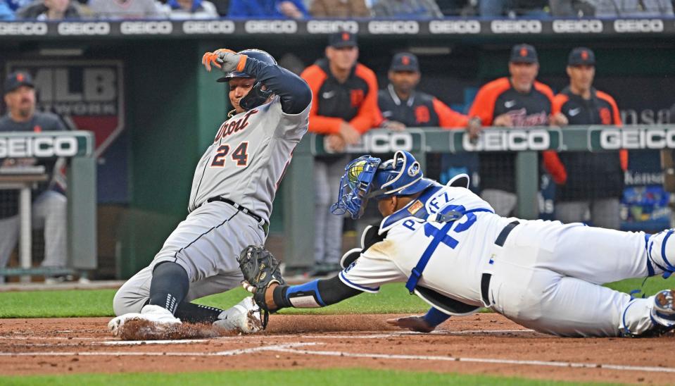Detroit Tigers designated hitter Miguel Cabrera (24) scores a run, sliding past Kansas City Royals catcher Salvador Perez (13) during the second inning on Thursday, April 14, 2022, at Kauffman Stadium in Kansas City, Mo.