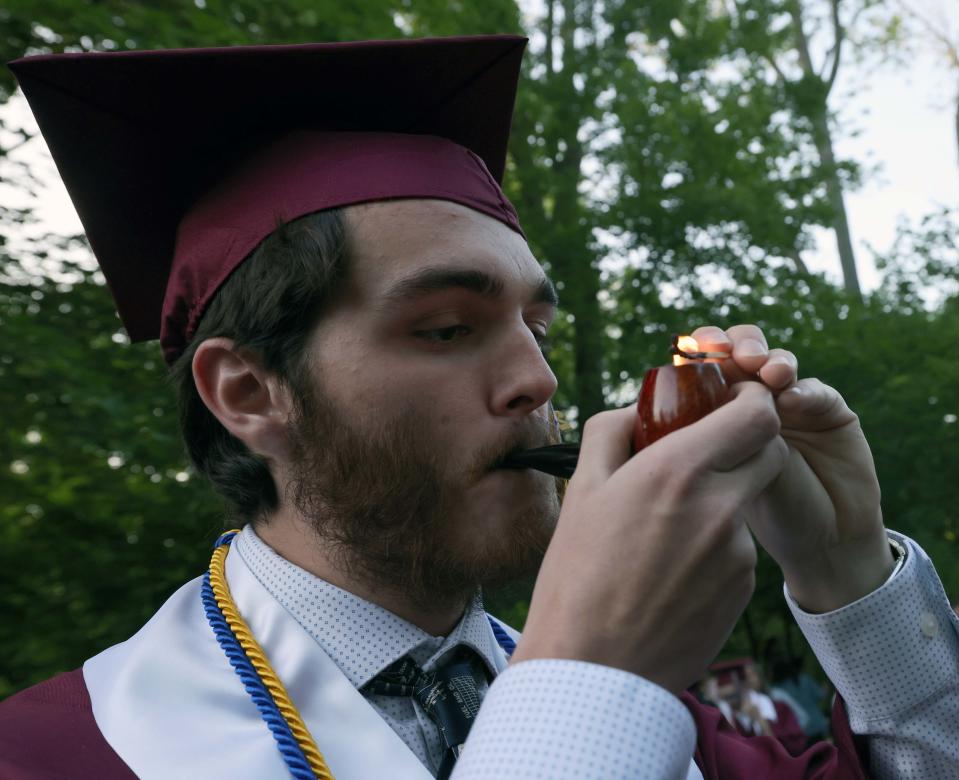 Sean Peterson lights-up a celebratory cigar following the West Bridgewater Middle-Senior High School graduation at War Memorial Park on Friday, May 26, 2023. 